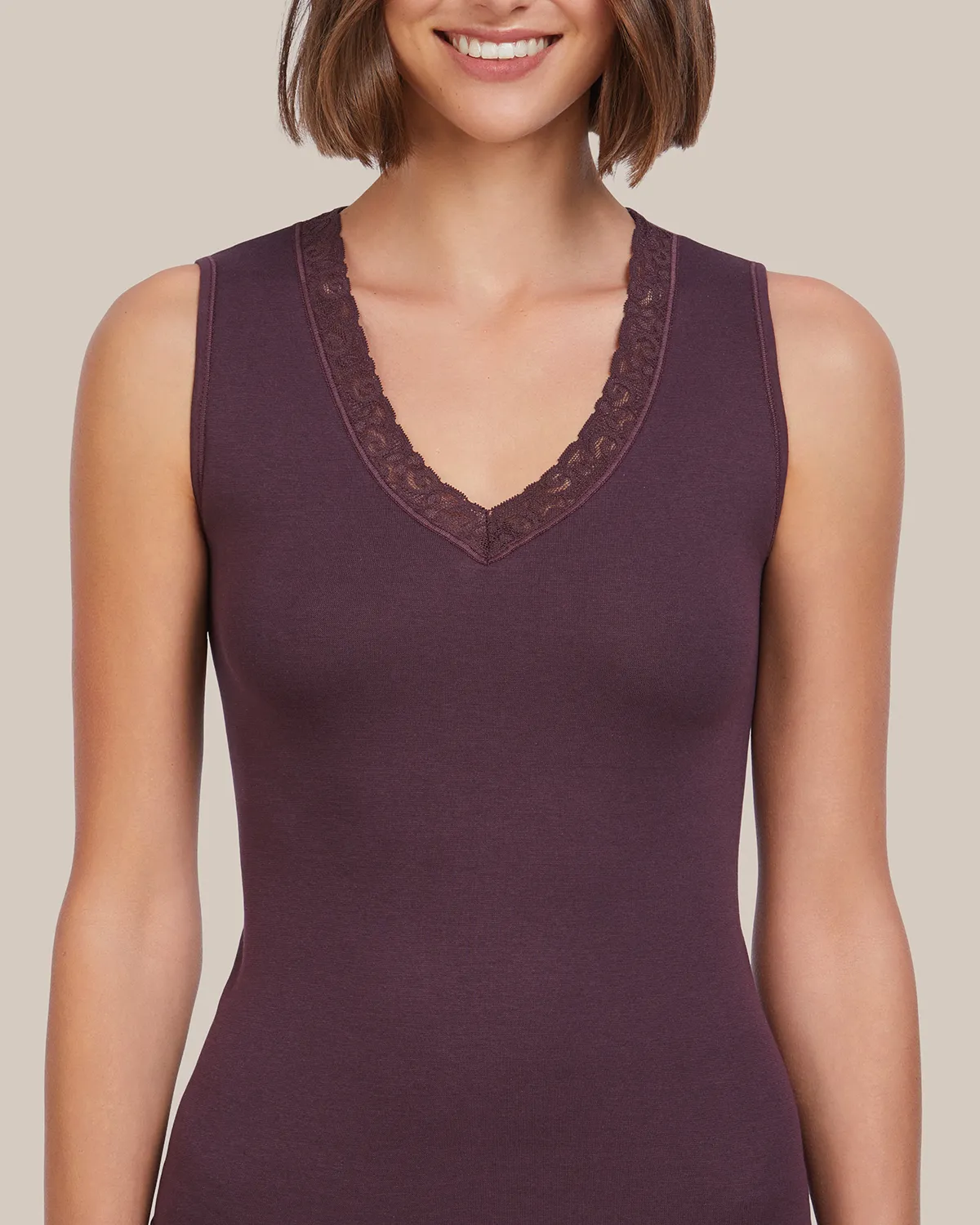 Fotografía de producto textil: detalle de top color granate con escote en V y ribete de encaje. Retoque profesional de e-commerce realizado por Somos Estrategia Visual en Barcelona.