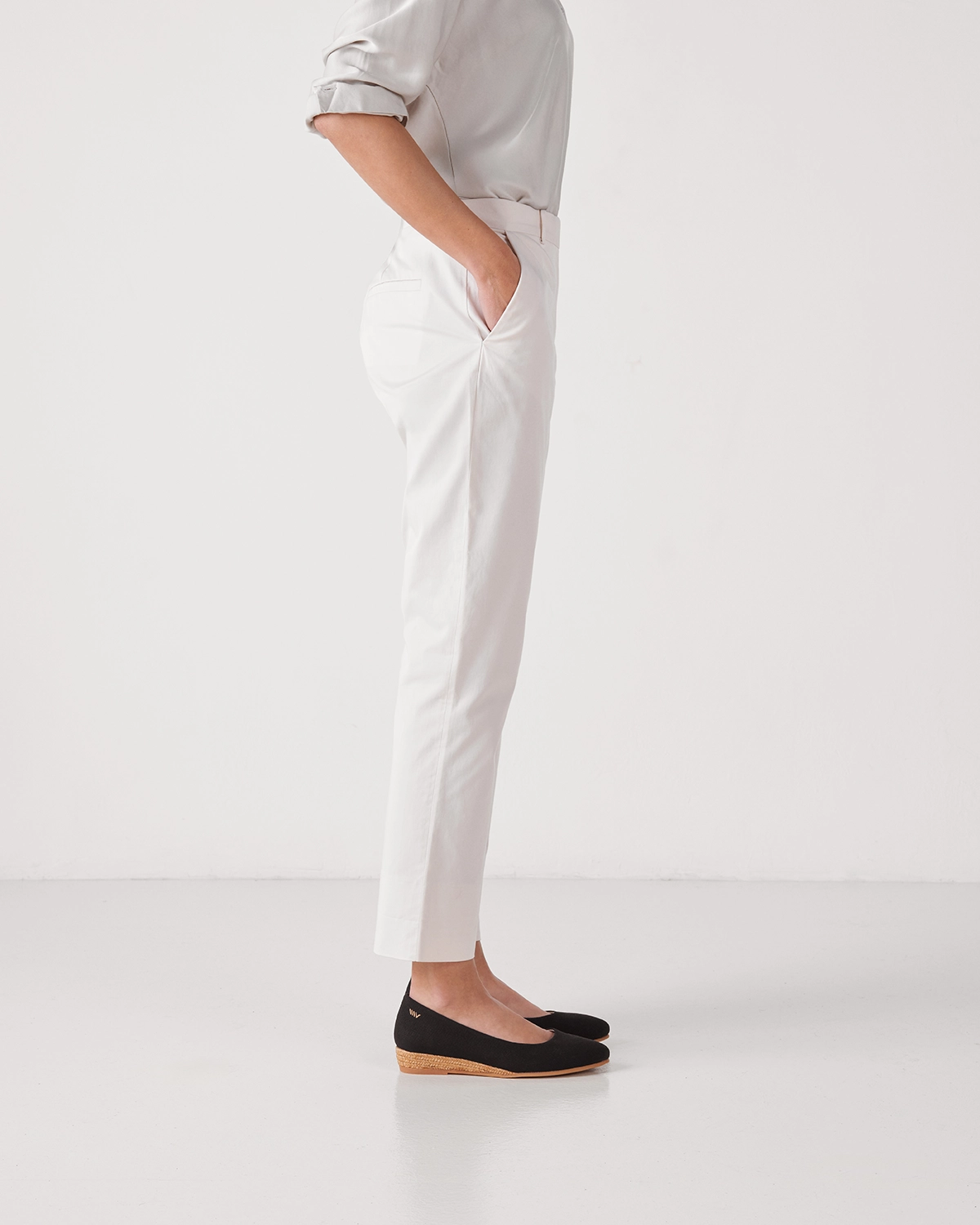 Modelo de perfil vistiendo pantalón blanco y calzado Viscata en una sesión de fotografía de catálogo de moda realizada en estudio en Barcelona.