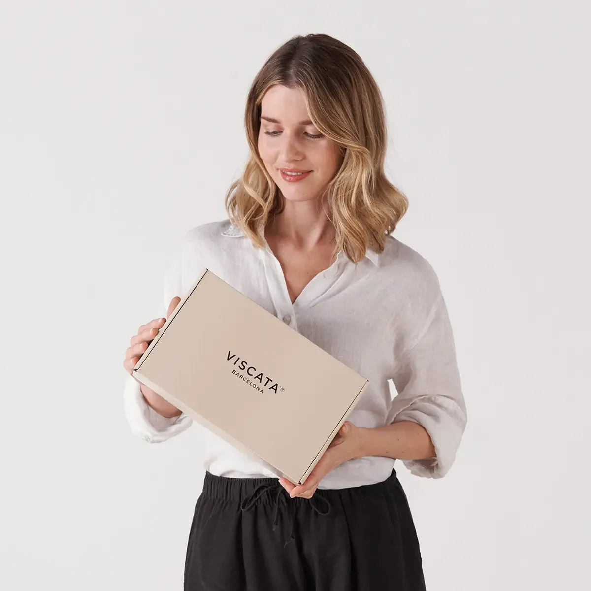 Retrato beauty de modelo mientras sujeta la caja de marca Viscata Barcelona en una sesión de new branding y fotografía publicitaria.